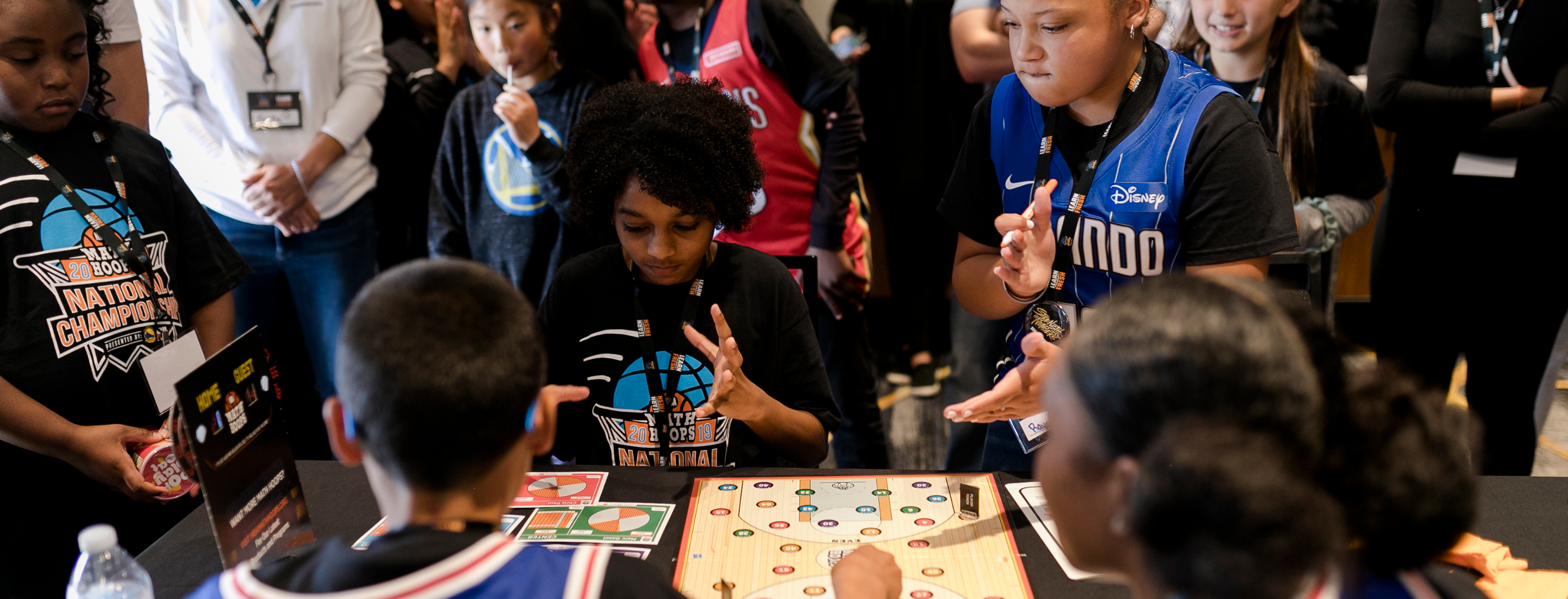 Students gathering around NBA Math Hoops board game